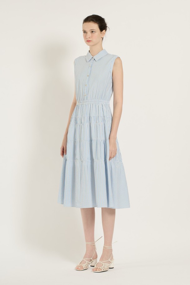 [25SU] 스트라이프 티어드 원피스는 스카이 블루 색상의 스트라이프 패턴이 돋보이는 민소매 티어드 원피스입니다. 레이온, 폴리에스터, 폴리우레탄 혼방 소재로 제작되어 부드러운 촉감과 우수한 통기성을 자랑하며, 안감이 있어 쾌적하게 착용할 수 있습니다. 칼라 디자인에 버튼 디테일이 더해졌으며, 넓게 퍼지는 스커트 라인이 우아하고 페미닌한 무드를 연출합니다.
