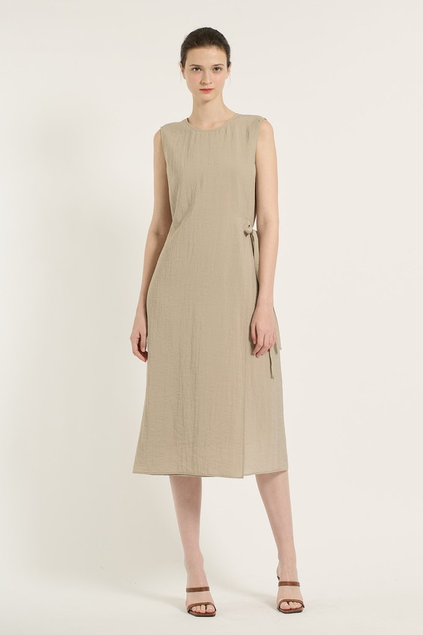 [25SU] 랩 원피스 - M BEIGE B5B6O65172는 여성 의류로, 미니멀하면서 엘레강스한 스타일을 연출합니다. M BEIGE 컬러의 얇은 두께, 부드러운 촉감의 레이온, 나일론, 린넨, 폴리에스테르 혼방 소재로 제작되었으며, 랩 디자인과 라운드넥이 특징입니다. 사이드 매듭 디테일과 자연스러운 플리츠, 민소매 디자인으로 여름철 데일리룩에 적합하며, 사계절 활용 가능한 실용적인 아이템입니다.
