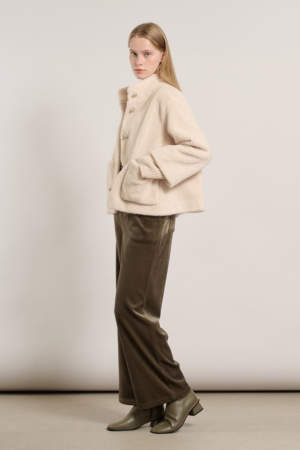 [25WT] 밴드넥 FAKE 무스탕 - IVORY A5WAF81513은 부드러운 촉감의 인조 가죽 소재로 제작된 여성용 무스탕입니다. 밴드넥 디자인과 크롭 기장으로 캐주얼하고 베이직한 스타일을 연출하며, 겨울철 따뜻하게 착용할 수 있습니다. 아이보리 컬러의 무지 디자인에 레귤러 핏으로 어떤 옷에도 쉽게 매치할 수 있습니다. 안감은 퍼 소재로 되어 있어 보온성을 높였으며, 긴 소매와 버튼 여밈 방식이 특징입니다.