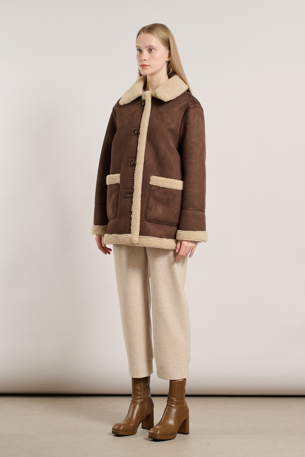 "25WT" 리버시블 페이크무스탕 - DARK BROWN A5WBF84275는 여성용 아우터로, 가을과 겨울에 따뜻하게 입을 수 있는 무스탕입니다. 다크 브라운 컬러의 무지 디자인으로, 캐주얼, 미니멀, 클래식 스타일을 연출하기 좋습니다. 부드러운 촉감의 인조 가죽과 퍼 소재를 사용하여 두꺼운 두께감을 자랑하며, 리버시블 디자인으로 다양한 스타일을 연출할 수 있습니다. 크롭 기장에 버튼 여밈 방식, 긴 소매와 레귤러핏으로 편안하게 착용 가능하며 페이크퍼 디테일이 돋보입니다.