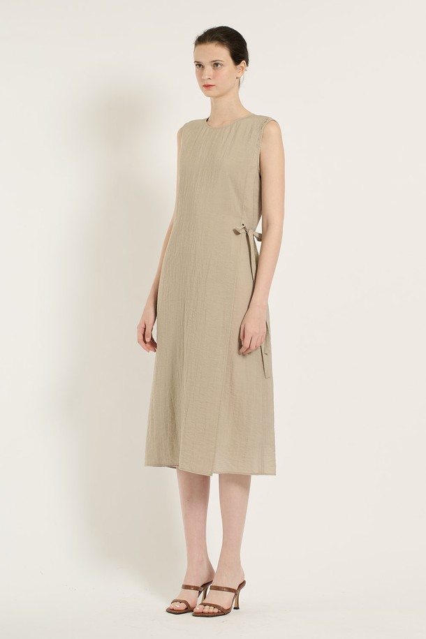 [25SU] 랩 원피스 - M BEIGE B5B6O65172는 여성 의류로, 미니멀하면서 엘레강스한 스타일을 연출합니다. M BEIGE 컬러의 얇은 두께, 부드러운 촉감의 레이온, 나일론, 린넨, 폴리에스테르 혼방 소재로 제작되었으며, 랩 디자인과 라운드넥이 특징입니다. 사이드 매듭 디테일과 자연스러운 플리츠, 민소매 디자인으로 여름철 데일리룩에 적합하며, 사계절 활용 가능한 실용적인 아이템입니다.
