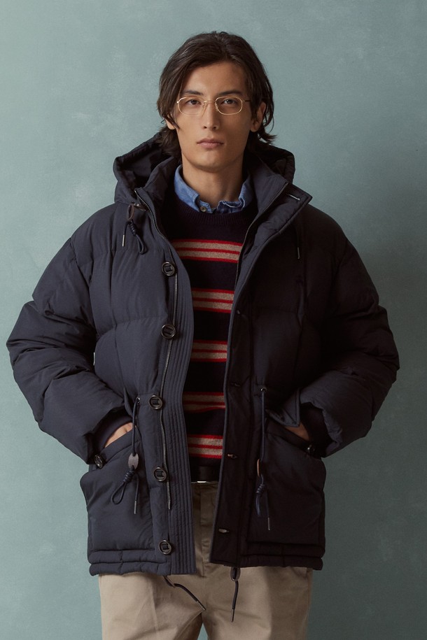 다크네이비 컬러의 카라코람 다운점퍼 (BBOPMBF405)는 겨울철 일상과 출근룩에 적합한 남성용 아우터입니다. 캐주얼하고 미니멀한 스타일의 무지 디자인으로, 오버핏 실루엣과 두꺼운 두께감으로 보온성을 높였습니다. 숏패딩 스타일의 이 점퍼는 버튼과 지퍼로 여밀 수 있으며, 후드와 포켓 디테일을 갖추어 실용성을 더했습니다. 방수 기능과 부드러운 촉감의 나일론 소재를 사용하여 편안한 착용감을 제공하며, 긴 소매 기장과 패딩 안감으로 따뜻함을 유지합니다.
