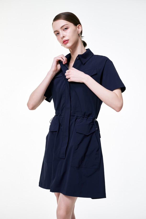 네이비 컬러의 아웃포켓 원피스입니다. 봄, 여름 시즌에 활용하기 좋은 얇은 두께의 반소매 원피스로, 캐주얼과 포멀 스타일을 모두 연출할 수 있습니다. 허리 스트링과 아웃포켓 디테일이 특징이며, 활동성을 더하는 A라인 플레어 치마핏과 루즈핏으로 편안하게 착용 가능합니다. 골프 및 일상에서 모두 활용 가능한 디자인이며, 속반바지가 내장되어 있어 더욱 실용적입니다. 소재는 나일론과 스판덱스를 사용하여 편안한 착용감을 제공합니다.
