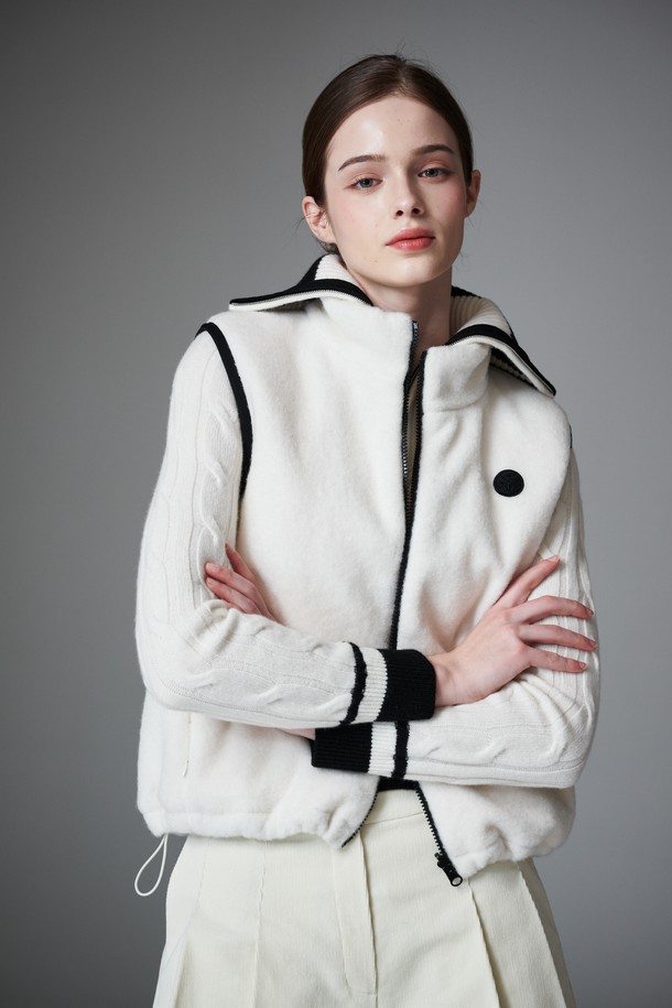 부클 리버시블 베스트는 여성 골프룩, 일상룩에 모두 활용 가능한 아우터입니다. 부드러운 촉감의 두꺼운 부클 소재로 제작되어 가을, 겨울철 따뜻하게 착용할 수 있습니다. 퀼팅 디테일과 패딩 안감으로 보온성을 높였으며, 민소매 디자인과 레귤러핏으로 스포티, 캐주얼, 미니멀 스타일을 소화하기 좋습니다. 앞면은 무지 스타일의 화이트 컬러, 뒷면은 리버시블 디자인으로 다양한 연출이 가능하며, 집업 여밈 방식과 레귤러 기장으로 편안함을 더했습니다.
