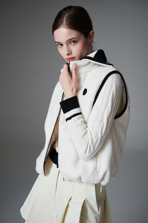 부클 리버시블 베스트는 여성 골프룩, 일상룩에 모두 활용 가능한 아우터입니다. 부드러운 촉감의 두꺼운 부클 소재로 제작되어 가을, 겨울철 따뜻하게 착용할 수 있습니다. 퀼팅 디테일과 패딩 안감으로 보온성을 높였으며, 민소매 디자인과 레귤러핏으로 스포티, 캐주얼, 미니멀 스타일을 소화하기 좋습니다. 앞면은 무지 스타일의 화이트 컬러, 뒷면은 리버시블 디자인으로 다양한 연출이 가능하며, 집업 여밈 방식과 레귤러 기장으로 편안함을 더했습니다.
