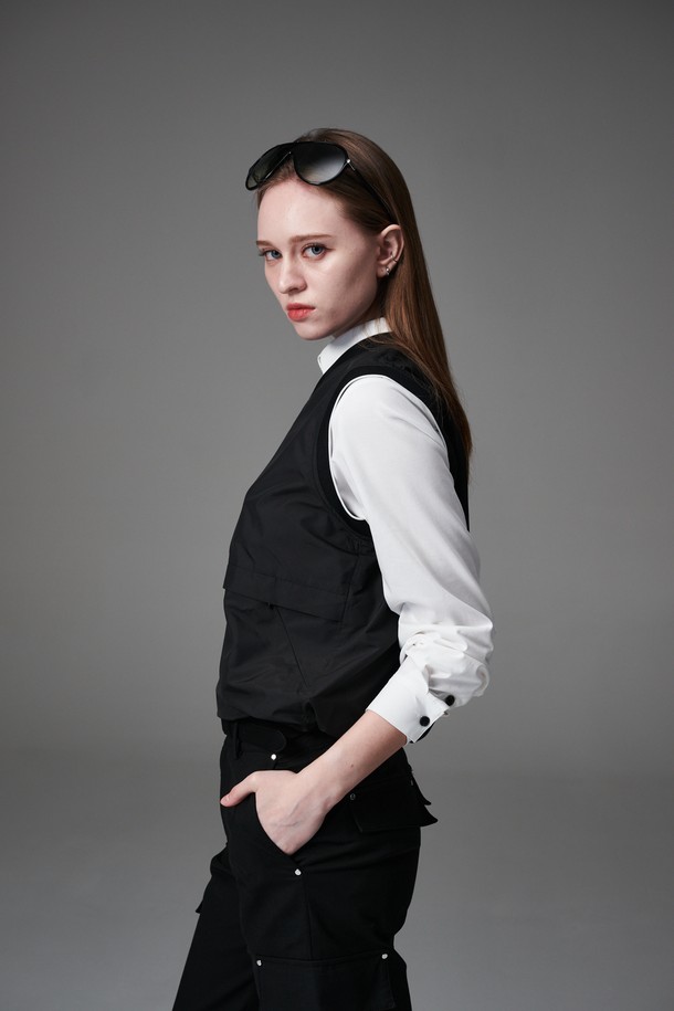 블랙 컬러의 여성용 방수 포켓 베스트입니다. 봄, 가을 시즌에 골프 또는 일상복으로 활용하기 좋은 레귤러핏 베스트로, 미니멀하고 베이직한 스타일을 연출합니다. 가볍고 얇은 폴리에스터 소재로 제작되었으며, 브이넥 디자인과 니트 암홀 마감으로 편안함을 더했습니다. 전면에 포켓 디테일이 있어 실용성을 높였으며, 니트 안감이 적용되었습니다.
