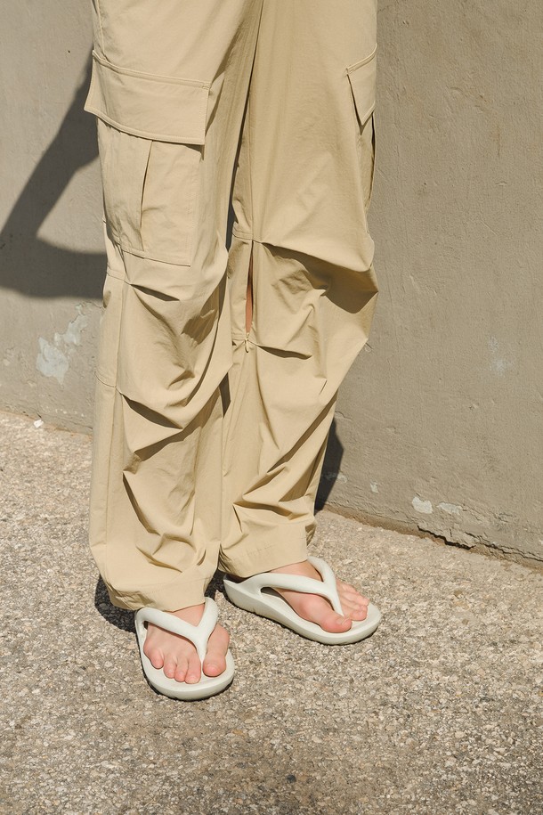 스트링 카고 팬츠는 여성 골프 및 일상용으로 제작된 여름 긴바지입니다. 베이지 색상으로, 나일론과 스판덱스 혼방 소재로 제작되어 시원한 촉감과 탄탄한 착용감을 제공합니다. 레귤러핏으로 캐주얼, 스포티, 미니멀 스타일을 연출하며, 무릎 안쪽 지퍼 및 턱 디테일이 특징입니다. 가볍고 얇은 두께로 활동성을 높여 골프룩에 적합합니다. 밴딩 처리로 편안한 착용감을 선사합니다.
