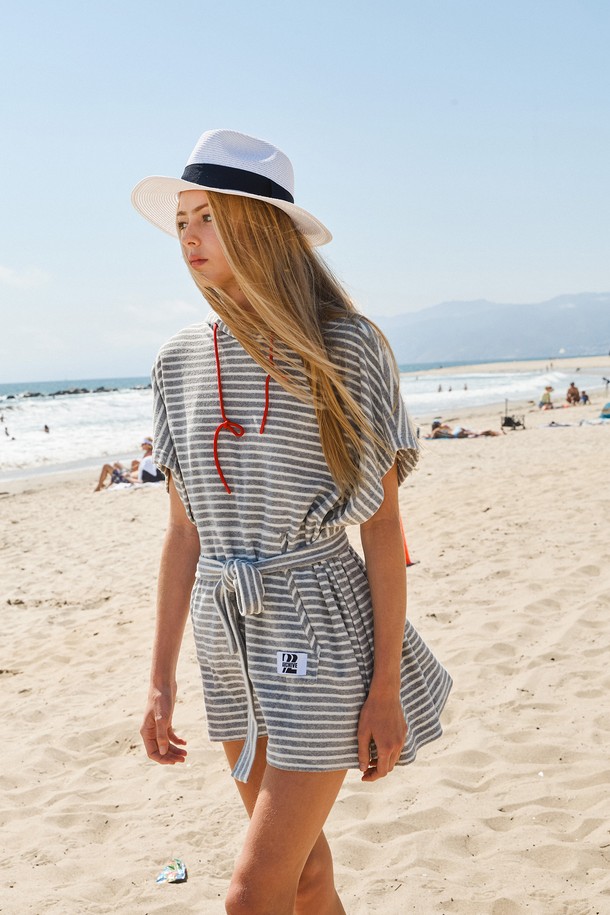 테리후드 케이프는 부드러운 테리 소재와 폴리에스테르 혼방으로 제작되어 부드러운 촉감을 선사합니다. 회색과 화이트 컬러의 스트라이프 패턴이 캐주얼한 무드를 연출하며, 여름철 수영장이나 해변에서 비치웨어, 휴가룩, 리조트룩으로 활용하기 좋습니다. 루즈핏 디자인에 반소매 기장, 후드 스타일로 편안함을 더하고, 버튼과 허리 벨트로 다양한 스타일을 연출할 수 있습니다. 미디엄 기장으로 편안하면서도 스타일리시하게 즐길 수 있는 케이프입니다.
