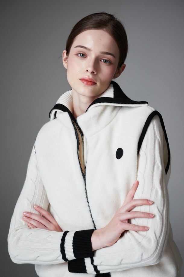 부클 리버시블 베스트는 여성 골프룩, 일상룩에 모두 활용 가능한 아우터입니다. 부드러운 촉감의 두꺼운 부클 소재로 제작되어 가을, 겨울철 따뜻하게 착용할 수 있습니다. 퀼팅 디테일과 패딩 안감으로 보온성을 높였으며, 민소매 디자인과 레귤러핏으로 스포티, 캐주얼, 미니멀 스타일을 소화하기 좋습니다. 앞면은 무지 스타일의 화이트 컬러, 뒷면은 리버시블 디자인으로 다양한 연출이 가능하며, 집업 여밈 방식과 레귤러 기장으로 편안함을 더했습니다.
