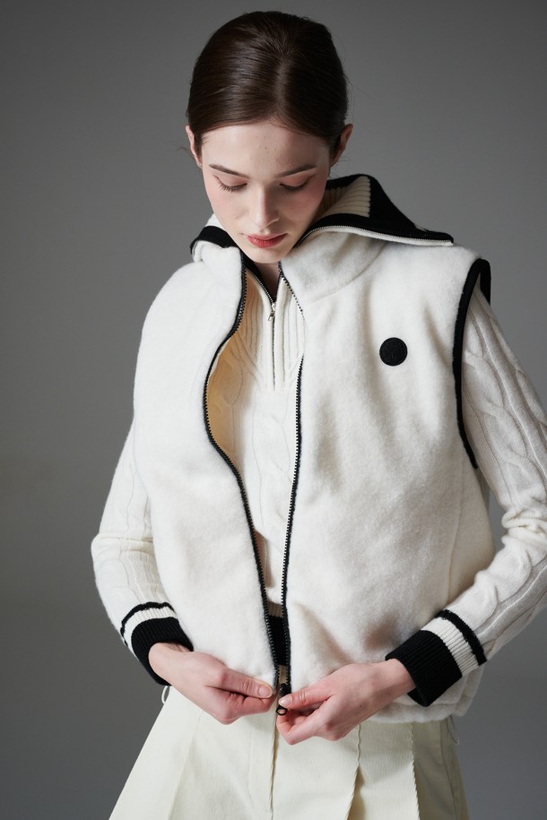 부클 리버시블 베스트는 여성 골프룩, 일상룩에 모두 활용 가능한 아우터입니다. 부드러운 촉감의 두꺼운 부클 소재로 제작되어 가을, 겨울철 따뜻하게 착용할 수 있습니다. 퀼팅 디테일과 패딩 안감으로 보온성을 높였으며, 민소매 디자인과 레귤러핏으로 스포티, 캐주얼, 미니멀 스타일을 소화하기 좋습니다. 앞면은 무지 스타일의 화이트 컬러, 뒷면은 리버시블 디자인으로 다양한 연출이 가능하며, 집업 여밈 방식과 레귤러 기장으로 편안함을 더했습니다.
