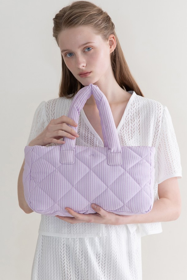 스트라이프 패딩 토트백 - 라벤더는 여성용 미디엄 사이즈 토트백입니다. 면과 폴리에스테르 혼방 소재로 제작되었으며, 라벤더, 스카이블루, 블랙 세 가지 색상으로 만나볼 수 있습니다. 가방 전면에 스트라이프 퀄팅 패딩 디자인과 자수 디테일이 돋보이며, 넉넉한 수납 공간을 제공합니다. 내부 지퍼 포켓과 오른쪽 포켓, 지퍼 잠금 방식으로 소지품을 안전하게 보관할 수 있으며, 상단 탈부착 기능으로 실용성을 더했습니다. 캐주얼, 미니멀, 클래식 스타일을 즐겨 입는 분들께 일상 및 가벼운 외출용으로 추천합니다.
