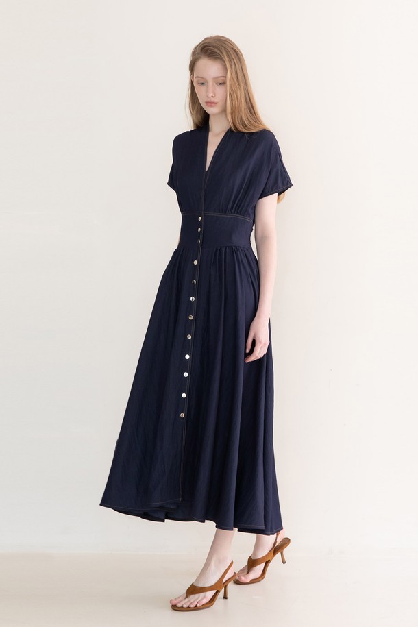 인디고 컬러의 Button 맥시 드레스는 여성스러운 분위기를 연출하는 맥시 기장의 원피스입니다. 어깨 서림 디테일과 가슴 스탠드칼라, 허리 뒷면 스모킹 디자인이 특징이며, 실버 버튼으로 포인트를 더했습니다. 레이온과 나일론 혼방 소재로 제작되어 봄, 여름에 시원하게 착용할 수 있습니다. 클래식하고 우아한 스타일로 데이트룩, 카페룩, 모임룩에 적합하며, 미니멀한 무드를 더해줍니다. 반소매 디자인으로 편안함과 스타일을 동시에 잡았습니다.
