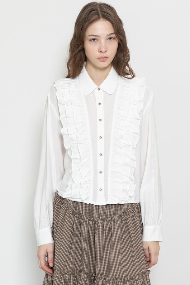 프릴 크롭 블라우스_2컬러는 여성스러운 무드를 연출하는 블라우스입니다. 칼라 디자인에 골드 로고 버튼 디테일이 더해져 고급스러운 느낌을 주며, 볼륨감 있는 프릴 장식이 로맨틱한 분위기를 자아냅니다. 크롭 기장으로 다리가 길어 보이는 효과를 주며, 봄, 여름에 화이트, 브라운 두 가지 색상 중 선택하여 데이트룩, 카페룩, 모임룩 등 다양한 TPO에 활용할 수 있습니다. 레이온과 나일론 혼방 소재로 제작되어 편안한 착용감을 선사하며, 단독 또는 레이어드하여 스타일리시하게 연출할 수 있습니다.
