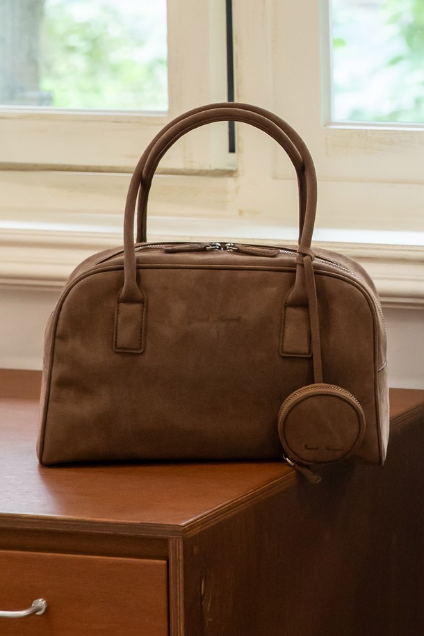 Stellar 스웨이드 보스턴백_2color는 부드러운 곡선 실루엣이 돋보이는 여성용 보스턴백입니다. 고급스러운 프리미엄 스웨이드 소재와 소가죽의 조화가 돋보이며, 미디엄 사이즈로 일상 및 여행룩에 적합합니다. 내부 지퍼와 사이드 포켓, 탈부착 가능한 액세서리를 갖춰 실용성을 높였으며, 지퍼형 잠금 방식으로 소지품을 안전하게 보관할 수 있습니다. 카멜 베이지 컬러의 무지 디자인으로 클래식하고 미니멀한 스타일을 연출합니다.
