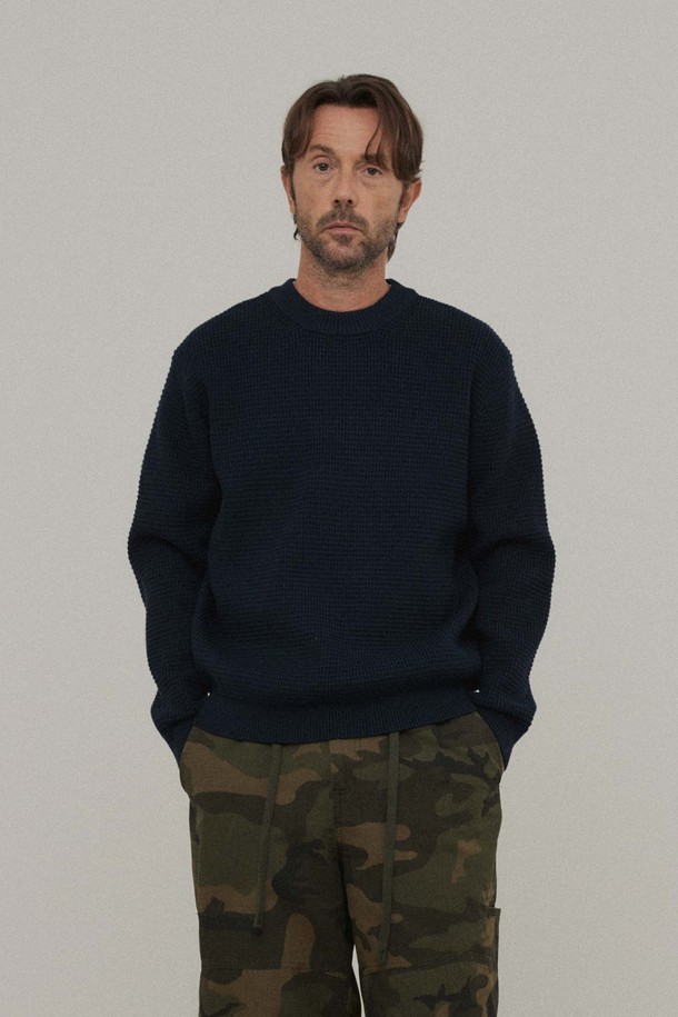 네이비 컬러의 와플 크루넥 니트입니다. 가을, 겨울 시즌에 어울리는 두꺼운 두께감과 스탠다드핏으로 제작되어 편안한 착용감을 선사합니다. 클래식하고 베이직한 스타일로, 와플 짜임이 특징이며, 긴소매 디자인입니다. 일상, 출근룩, 비즈니스 캐주얼 등 다양한 TPO에 활용하기 좋습니다. 후면에는 포인트 라벨이 더해져 미니멀하면서도 세련된 느낌을 줍니다.
