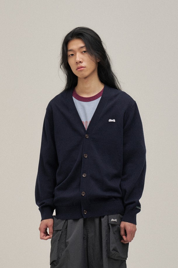 네이비 컬러의 클래식 V넥 가디건입니다. 면 100% 원사를 사용하여 부드러운 촉감을 선사하며, 봄 시즌 데이트룩과 카페룩에 잘 어울립니다. 스탠다드 핏으로 제작되었으며, 소매와 밑단 립조직 마감으로 깔끔함을 더했습니다. 가슴 자수 와펜 디테일과 소맷단 포인트 라벨, 르티그레 레터링 로고 단추가 특징입니다. 베이직하면서도 미니멀한 스타일을 연출하기 좋습니다.
