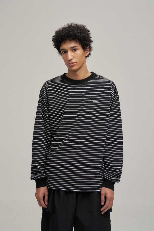 블랙 컬러의 스트라이프 긴소매 티셔츠입니다. 부드러운 면 100% 소재로 제작되어 편안한 착용감을 제공하며, 사계절 내내 활용 가능한 실용적인 아이템입니다. 루즈 핏으로 캐주얼한 스타일을 연출하며, 손목 시보리와 가슴 자수 와펜, 소맷단 직자수 디테일로 포인트를 더했습니다. 라운드넥 디자인으로 다양한 스타일과 레이어드하여 연출하기 좋습니다. 데일리룩, 미니멀룩에 활용하기 좋은 기본 아이템입니다.
