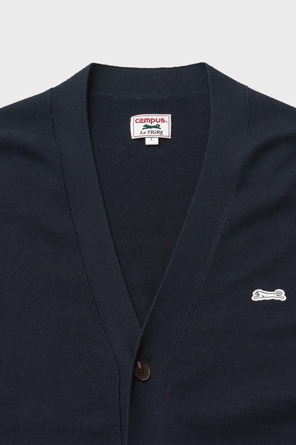네이비 컬러의 클래식 V넥 가디건입니다. 면 100% 원사를 사용하여 부드러운 촉감을 선사하며, 봄 시즌 데이트룩과 카페룩에 잘 어울립니다. 스탠다드 핏으로 제작되었으며, 소매와 밑단 립조직 마감으로 깔끔함을 더했습니다. 가슴 자수 와펜 디테일과 소맷단 포인트 라벨, 르티그레 레터링 로고 단추가 특징입니다. 베이직하면서도 미니멀한 스타일을 연출하기 좋습니다.
