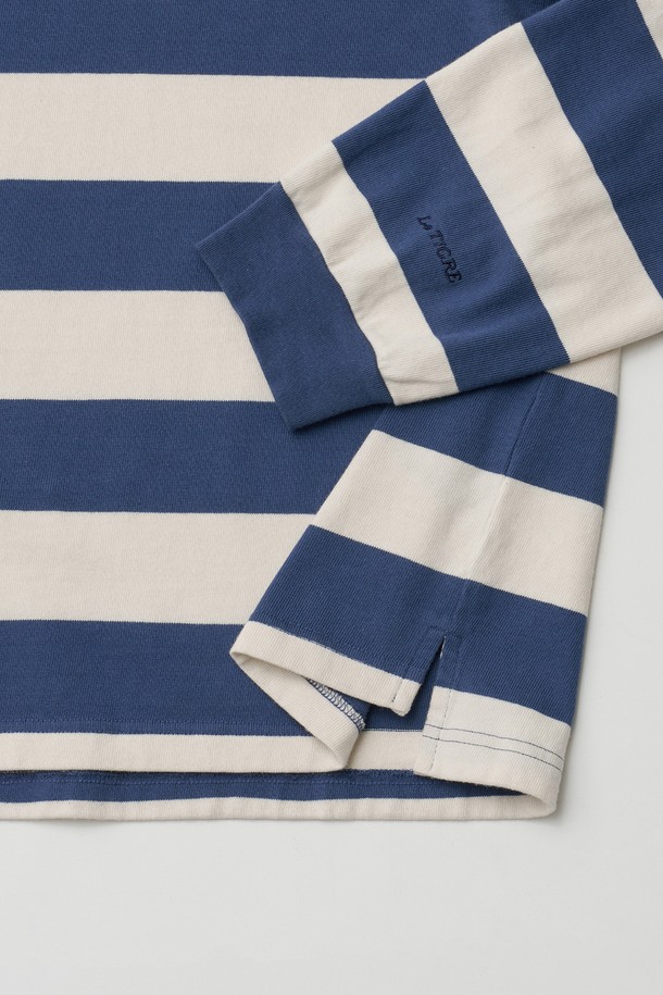 에크루-블루 컬러의 럭비 스트라이프 긴소매 티셔츠입니다. 부드러운 면 소재로 제작되었으며, 레귤러 핏과 적당한 두께감으로 편안하게 착용할 수 있습니다. 차이나칼라 디자인에 우븐 카라, 가슴 자수 와펜, 소맷단 직자수, 밑단 트임, 헤링본테잎 디테일, 르티그레 로고 단추 등 레트로 무드를 더하는 섬세한 디테일이 돋보입니다. 캐주얼, 클래식 스타일을 즐기는 남성분들께 데이트룩, 카페룩으로 추천합니다. 봄 시즌에 활용하기 좋은 아이템입니다.
