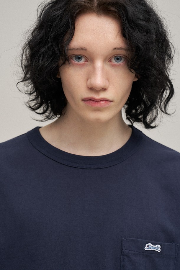 네이비 컬러의 클래식 포켓 티셔츠입니다. 면 소재로 제작되어 봄, 여름 시즌에 편안하게 착용하기 좋으며, 스탠다드핏과 라운드넥 디자인으로 베이직하고 캐주얼한 스타일을 연출합니다. 가볍게 동네 마실을 나가거나 카페에서 여유를 즐길 때 멋스럽게 코디할 수 있습니다. 심플한 무지 디자인에 포켓 디테일을 더해 미니멀하면서도 클래식한 무드를 더했습니다. 반소매 기장으로 활동성이 뛰어나 데일리룩으로 활용하기 좋습니다.
