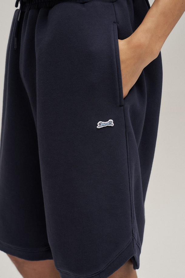 네이비 컬러의 클래식 스웻 쇼츠입니다. 부드러운 면 소재로 제작되어 편안한 착용감을 선사하며, 봄, 여름 시즌에 활용하기 좋습니다. 루즈핏과 오버핏으로 디자인되어 캐주얼하고 스포티한 스타일을 연출하며, 워싱 처리로 자연스러운 느낌을 더했습니다. 활동성을 높이는 사이드 슬릿 디테일이 돋보이며, 밴딩 처리된 허리 부분은 편안한 착용감을 제공합니다. 동네 마실룩, 여행룩, 집콕룩 등 다양한 TPO에 맞춰 미니멀하고 세련된 스타일을 완성해보세요.
