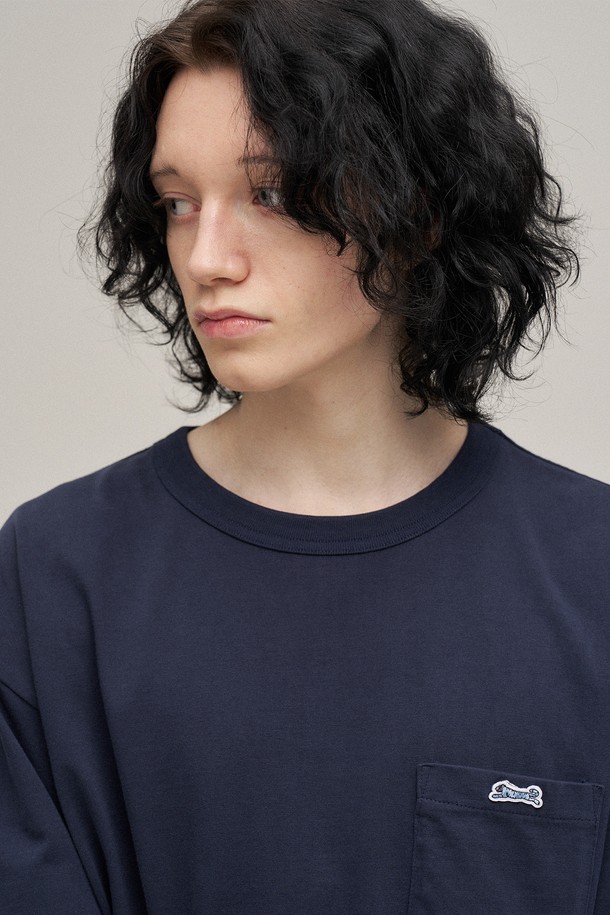 네이비 컬러의 클래식 포켓 티셔츠입니다. 면 소재로 제작되어 봄, 여름 시즌에 편안하게 착용하기 좋으며, 스탠다드핏과 라운드넥 디자인으로 베이직하고 캐주얼한 스타일을 연출합니다. 가볍게 동네 마실을 나가거나 카페에서 여유를 즐길 때 멋스럽게 코디할 수 있습니다. 심플한 무지 디자인에 포켓 디테일을 더해 미니멀하면서도 클래식한 무드를 더했습니다. 반소매 기장으로 활동성이 뛰어나 데일리룩으로 활용하기 좋습니다.
