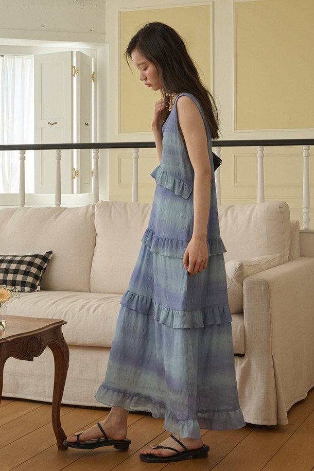 블루 미스트 색상의 Sleeveless Ruffle Tiered 롱 드레스입니다. 얇고 부드러운 시폰 소재로 제작되어 쿨터치 촉감을 선사하며, 봄, 여름 계절에 시원하게 착용하기 좋습니다. V넥 라인과 릴랙스 핏 디자인으로 편안하면서도 로맨틱하고 페미닌한 무드를 연출합니다. 티어드 치마와 러플 디테일, 캐스케이딩 러플이 더해져 여성스러운 실루엣을 강조하며, 데이트룩, 휴가룩, 리조트룩에 잘 어울립니다.

