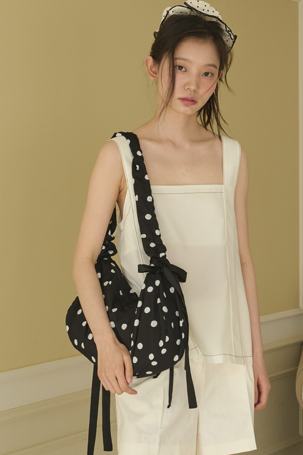 바운티 도트 숄더백_블랙은 부드러운 폴리에스터와 면 소재로 제작되어 편안한 착용감을 선사합니다. 블랙과 화이트 컬러의 도트 무늬가 돋보이며, 반원 모양의 디자인에 리본 장식이 더해져 걸리시하고 로맨틱한 스타일을 연출합니다. 미디엄 사이즈로 넉넉한 수납공간을 제공하며, 내부 작은 포켓과 길이 조절 가능한 스트랩이 실용성을 더합니다. 오픈형 잠금 방식으로 내용물을 쉽게 넣고 꺼낼 수 있으며, 크로스백 또는 토트백으로 활용 가능하여 일상, 여행, 피크닉 등 다양한 용도로 사용하기 좋습니다.
