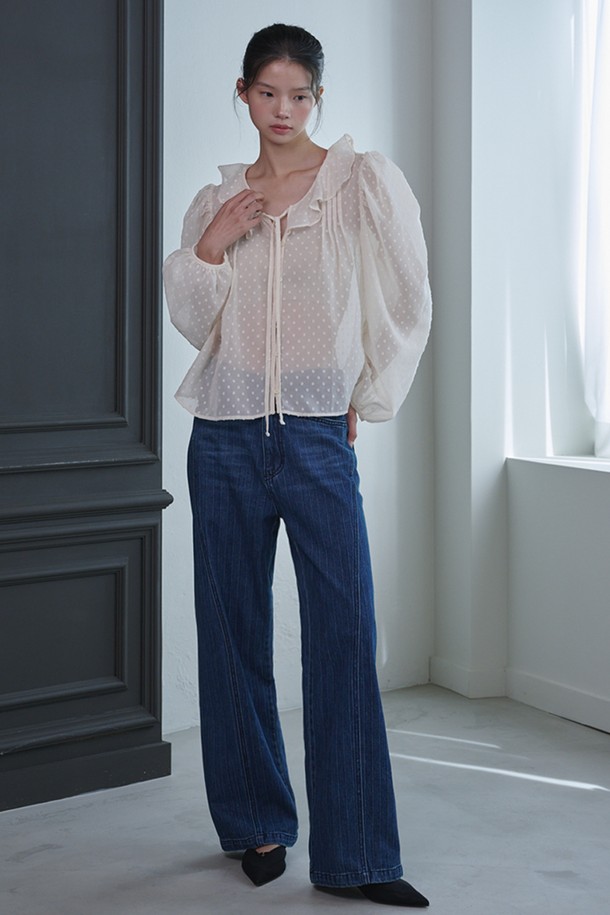 **러플 시스루 도트 블라우스_아이보리**는 페미닌하고 우아한 무드를 연출하는 여성 블라우스입니다. 부드러운 폴리에스테르 소재로 제작되어 봄, 여름, 가을 계절에 착용하기 좋으며, 얇은 두께감으로 시원하게 입을 수 있습니다. 라운드 넥과 긴 소매, 레귤러 핏으로 디자인되었으며, 러플 넥 라인과 스트링 디테일이 여성스러운 포인트를 더합니다. 중앙 버튼 여밈과 시스루 소재, 도트 패턴이 특징이며, 데이트룩, 카페룩, 모임룩 등 다양한 TPO에 클래식, 로맨틱, 미니멀 스타일로 연출하기 좋습니다.
