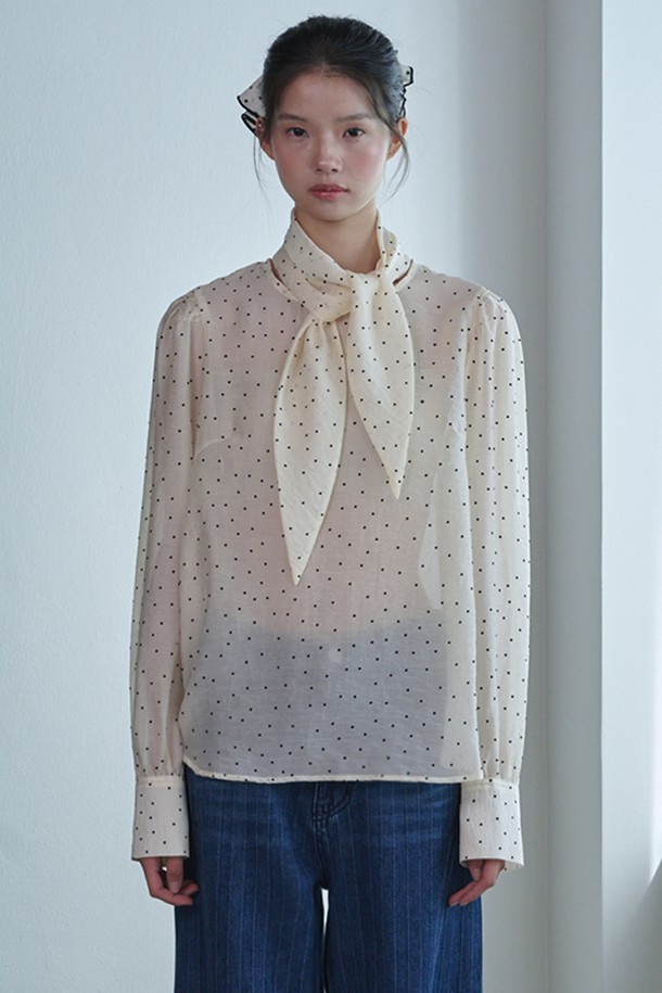 "Dot Scarf Blouse_아이보리"는 여성스러운 무드를 연출하는 블라우스입니다. 부드러운 촉감의 얇은 텍스타일과 나일론 혼방 소재로 제작되어 봄, 여름 시즌에 시원하게 착용하기 좋습니다. 페미닌하고 엘레강스한 스타일을 완성하며, 루즈핏 디자인과 긴 소매, 라운드넥, 도트 패턴이 특징입니다. 특히 퍼프 소매와 숄더 디테일, 뒷목 버튼 고정형 탈부착 스카프가 돋보이며 시스루 소재로 은은한 매력을 더합니다. 데이트룩, 모임룩, 소개팅룩 등 다양한 TPO에 클래식하고 로맨틱한 분위기를 연출할 수 있습니다.
