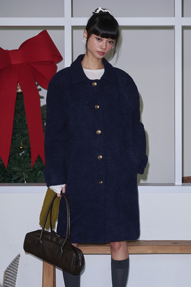 네이비 컬러의 Boucle(부클) 래글런 싱글 울 롱 코트는 여성 고객을 위한 클래식하고 미니멀한 디자인의 코트입니다. 부드러운 촉감의 두꺼운 울 소재로 제작되어 가을, 겨울 시즌에 따뜻하게 착용할 수 있습니다. 래글런 소매 디테일이 돋보이며, 싱글 버튼 여밈 방식과 롱 기장으로 세련된 실루엣을 연출합니다. 출근룩, 오피스룩, 모임룩 등 다양한 TPO에 활용 가능하며, 시크한 스타일을 완성합니다.
