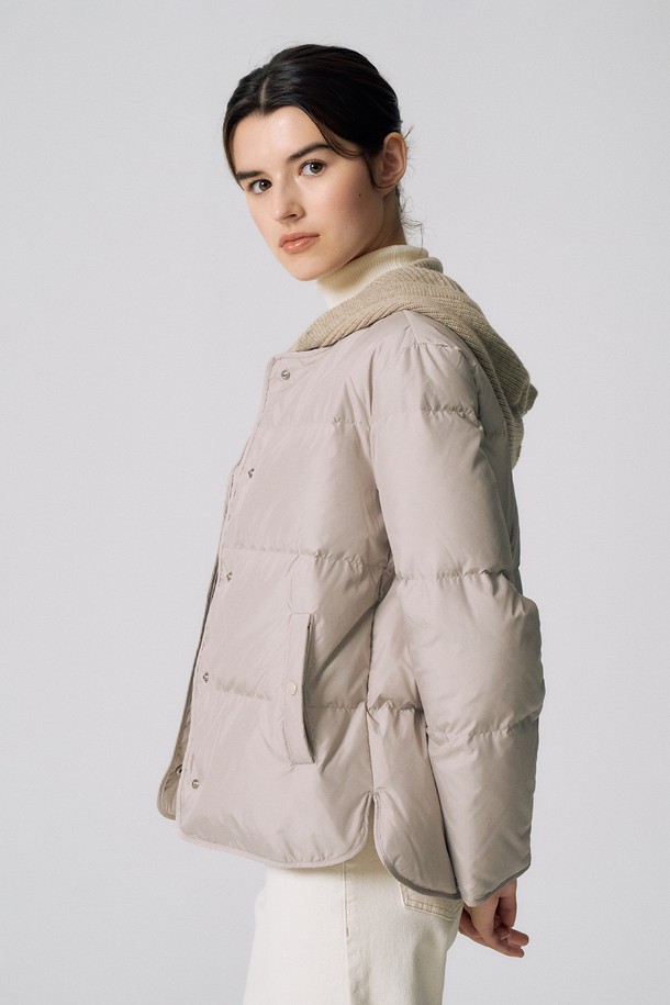 **니트 후드 버튼 패딩 E5HW026**은 겨울철 따뜻함과 스타일을 동시에 잡을 수 있는 여성용 아우터입니다. 부드러운 니트 소재에 두꺼운 두께감으로 포근한 착용감을 선사하며, 베이지 컬러와 무지 패턴이 미니멀하고 캐주얼한 분위기를 연출합니다. 크롭 기장에 버튼 여밈 방식, 후드 디테일이 더해져 트렌디한 디자인을 완성합니다. 레귤러핏으로 편안하게 착용 가능하며, 긴 소매와 안감 패딩으로 보온성을 높였습니다. 
