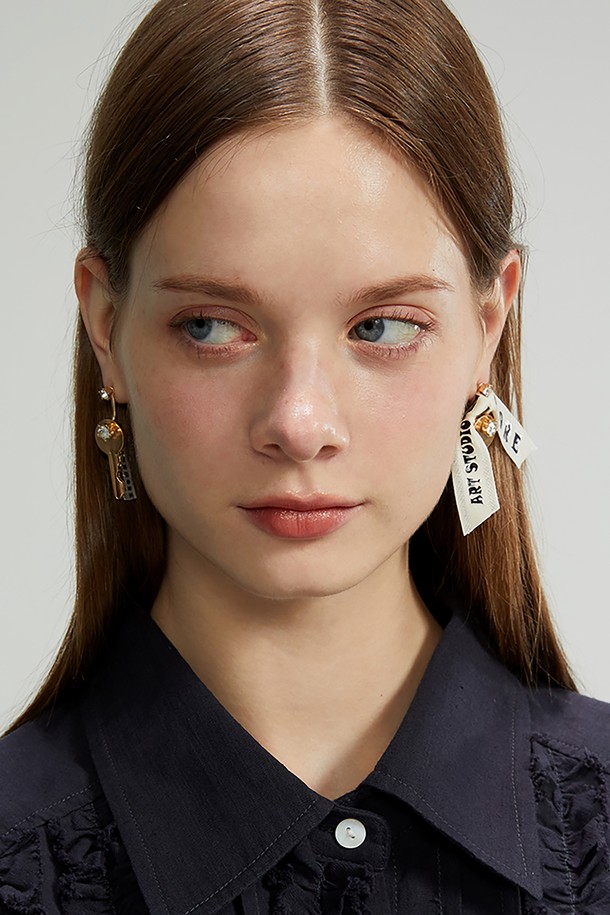 열쇠 모양 귀걸이는 큐브와 열쇠 디자인이 조화롭게 연결된 여성용 귀걸이입니다. 골드 컬러에 에폭시 소재로 제작되었으며, 한쪽은 로고 에폭시, 다른 쪽은 열쇠가 달린 로고 테이프로 포인트를 주었습니다. 양면의 사이즈와 패턴이 다르며, 로고 테이프와 에폭시 로고는 분리하여 다양한 스타일 연출이 가능합니다. 4.5~5.5cm의 적당한 크기로, 캐주얼, 페미닌 스타일 모두 소화 가능하며 모임룩, 데이트룩에 매치하면 세련된 포인트를 더할 수 있습니다.
