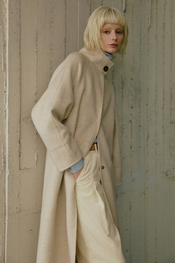부드러운 촉감의 캐시미어, 울, 실크 혼방 소재로 제작된 핸드메이드 하이넥 롱 코트입니다. 오트밀, 브라운, 차콜 세 가지 색상으로 출시되었으며, A라인과 릴렉스 핏으로 편안하면서도 세련된 실루엣을 연출합니다. 하이넥 디자인과 백 플리팅 디테일이 특징이며, 히든 스냅 버튼으로 깔끔하게 여밈이 가능합니다. 롱 기장과 긴 소매로 보온성을 높였으며, 안감 처리로 부드러운 착용감을 선사합니다. 출근룩, 오피스룩, 겨울 데일리룩 등 다양한 TPO에 클래식, 미니멀, 시크한 스타일을 더해줍니다.
