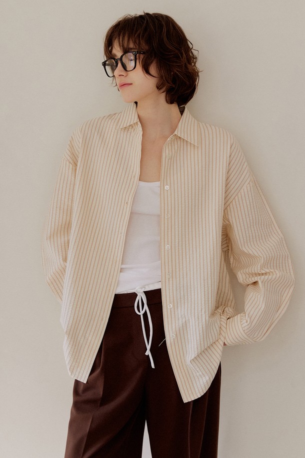 [2차 리오더] 시어서커 오버핏 스트라이프 셔츠 [브라운]는 시원한 시어서커 소재로 제작되어 봄, 여름에 쾌적하게 착용하기 좋습니다. 얇은 두께감과 부드러운 촉감으로 편안함을 더하며, 차이나칼라와 오버핏 디자인으로 캐주얼하고 트렌디한 스타일을 연출합니다. 브라운, 핑크, 그린 세 가지 컬러의 스트라이프 패턴으로 다양한 코디에 활용 가능하며, 사이드 슬릿 디테일로 활동성을 높였습니다. 데이트룩, 카페룩 등 다양한 TPO에 맞춰 단독 또는 레이어드하여 개성 있는 스타일을 완성해 보세요.
