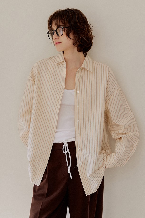 [2차 리오더] 시어서커 오버핏 스트라이프 셔츠 [브라운]는 시원한 시어서커 소재로 제작되어 봄, 여름에 쾌적하게 착용하기 좋습니다. 얇은 두께감과 부드러운 촉감으로 편안함을 더하며, 차이나칼라와 오버핏 디자인으로 캐주얼하고 트렌디한 스타일을 연출합니다. 브라운, 핑크, 그린 세 가지 컬러의 스트라이프 패턴으로 다양한 코디에 활용 가능하며, 사이드 슬릿 디테일로 활동성을 높였습니다. 데이트룩, 카페룩 등 다양한 TPO에 맞춰 단독 또는 레이어드하여 개성 있는 스타일을 완성해 보세요.
