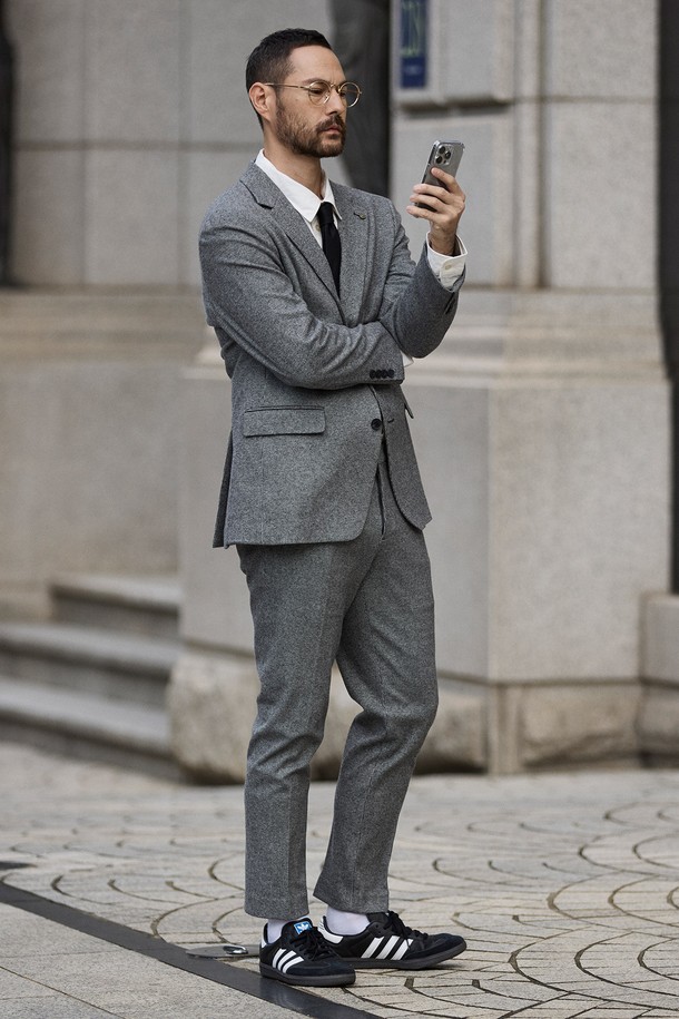 모션프리 저지 셋업 재킷_그레이는 남성용 셋업 재킷입니다. 울 혼방 소재의 부드러운 촉감과 중간 두께감으로 봄, 가을, 초겨울까지 착용하기 좋습니다. 마이크로 체크 패턴에 릴렉스 핏으로 제작되어 편안하면서도 모던하고 포멀한 스타일을 연출합니다. 출근룩, 하객룩, 비즈니스 캐주얼 등 다양한 TPO에 활용 가능하며, 자연스러운 어깨 라인과 싱글 버튼 여밈, 노치드 라펠, 플랩 포켓, 사이드 벤트 등의 디테일이 돋보입니다. 클래식하고 미니멀한 스타일을 선호하는 남성에게 추천합니다.
