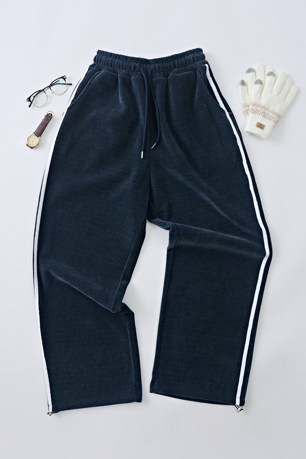 네이비 컬러의 트랙 세미 벨로아 와이드 팬츠는 여성들을 위한 캐주얼, 스포티, 스트리트 스타일의 바지입니다. 부드러운 벨루어 소재와 스판덱스 혼방으로 제작되어 편안한 착용감을 선사하며, 봄, 가을, 겨울 세 계절 모두 활용 가능합니다. 허리 스트링과 밴딩 디테일, 사이드 포켓, 핀턱 디테일, 신축성까지 갖춰 활동성을 높였습니다. 넉넉한 세미 와이드 핏으로 일상, 피트니스, 러닝, 워킹 등 다양한 TPO에 활용할 수 있습니다. 무지 디자인과 스트라이프 패턴으로 출시되어 취향에 맞게 선택 가능합니다.
