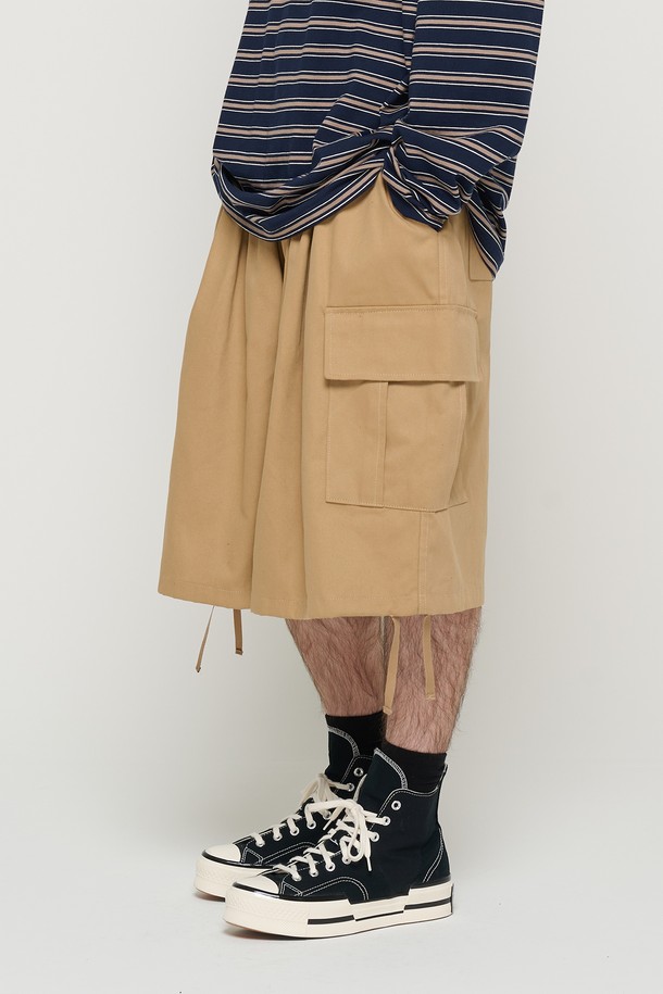 면 소재의 베이지 색상 카고 반바지로, 남녀 모두 편안하게 착용할 수 있는 루즈핏의 벌룬 실루엣 디자인입니다. 밑단 스트링과 사이드 포켓 디테일이 돋보이며, 허리 밴딩으로 일상에서 캐주얼하게 즐겨 입기 좋습니다. 봄, 여름 시즌에 적합하며 부드러운 촉감이 특징입니다.
