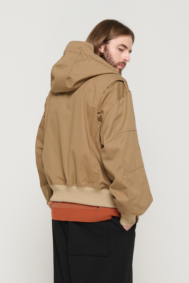 베이지 색상의 후드 밀리터리 자켓으로, 봄과 가을에 캐주얼하게 착용하기 좋습니다. 면 소재로 제작되었으며, 후드 디자인과 바이저, 커버드 지퍼, 다양한 절개 라인이 특징입니다. 남성용 레귤러 핏의 긴소매 집업 스타일로, 밀리터리 무드를 연출할 수 있습니다.
