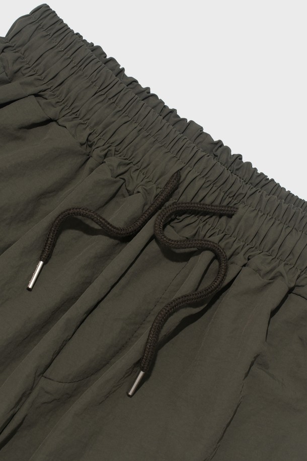 부드러운 촉감의 나일론 소재로 제작된 핀턱 디테일의 버뮤다 팬츠입니다. 루즈핏으로 편안하게 착용 가능하며, 허리 밴딩과 드로우스트링으로 사이즈 조절이 용이합니다. 봄, 여름 시즌 캐주얼 스타일을 연출하기 좋은 5부 기장의 카키색 바지입니다.
