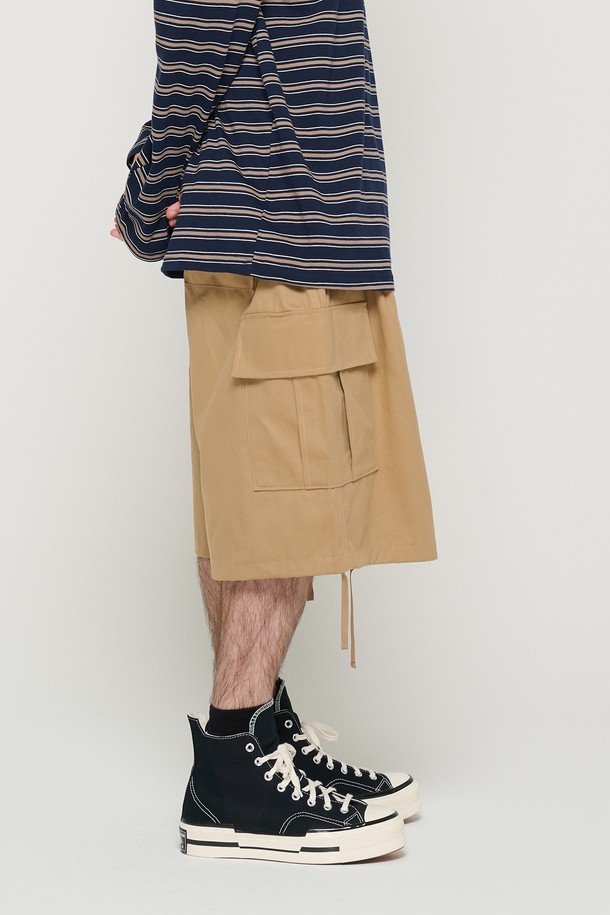 면 소재의 베이지 색상 카고 반바지로, 남녀 모두 편안하게 착용할 수 있는 루즈핏의 벌룬 실루엣 디자인입니다. 밑단 스트링과 사이드 포켓 디테일이 돋보이며, 허리 밴딩으로 일상에서 캐주얼하게 즐겨 입기 좋습니다. 봄, 여름 시즌에 적합하며 부드러운 촉감이 특징입니다.
