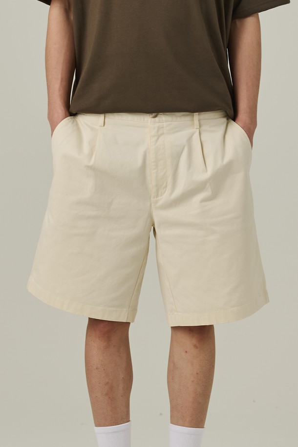 남성용 아이보리 색상의 코튼 핀턱 반바지입니다. 베이직하고 캐주얼한 무드를 연출하며, 핀턱 디테일과 앞주머니, 치노 스타일이 돋보입니다. 면 소재로 제작되었고, 세미와이드 루즈핏으로 편안하게 착용할 수 있는 여름 시즌 반바지입니다.
