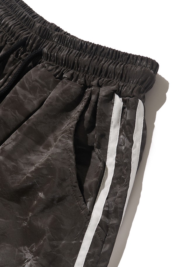 차콜 색상의 트랙 버뮤다 팬츠는 폴리에스테르 소재로 제작되어 봄, 여름철 일상 및 트레이닝에 적합합니다. 스트릿, 스포티, 캐주얼 무드를 연출하며 트럭 스타일 패턴이 돋보이는 루즈핏 디자인입니다. 엘라스틱 밴드와 얇은 두께로 편안한 착용감을 제공하며 데일리 코디에 용이합니다.
