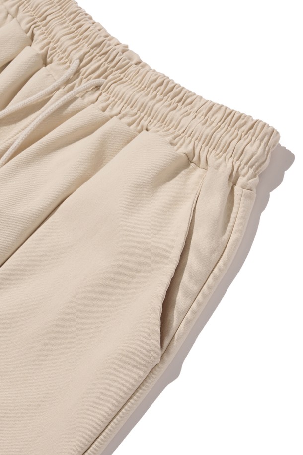 부드러운 면 소재로 제작된 아이보리 컬러의 밴딩 와이드 팬츠입니다. 베이직하고 캐주얼한 스타일로, 사계절 내내 편안하게 착용 가능한 루즈핏의 긴바지입니다. 밴딩 처리로 편안한 착용감을 제공하며, 드레이프성이 좋아 자연스러운 실루엣을 연출합니다.
