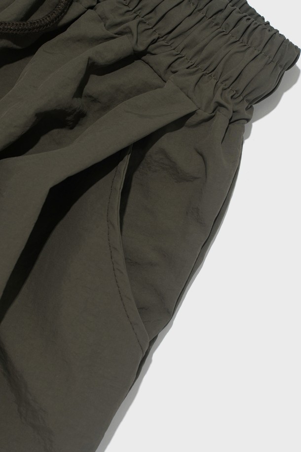 부드러운 촉감의 나일론 소재로 제작된 핀턱 디테일의 버뮤다 팬츠입니다. 루즈핏으로 편안하게 착용 가능하며, 허리 밴딩과 드로우스트링으로 사이즈 조절이 용이합니다. 봄, 여름 시즌 캐주얼 스타일을 연출하기 좋은 5부 기장의 카키색 바지입니다.
