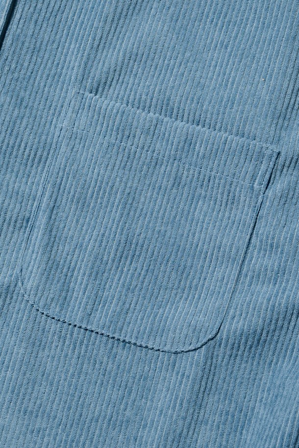 클래식 코듀로이 세미 셔츠 (블루)는 가을과 겨울에 어울리는, 부드러운 촉감의 두꺼운 코듀로이 소재로 제작된 남녀 공용 셔츠입니다. 차이나 칼라와 루즈핏 디자인으로 클래식하면서도 캐주얼한 스타일을 연출하며, 출근룩이나 비즈니스 캐주얼에 활용하기 좋습니다. 긴 소매와 포켓 디테일이 돋보이며, 무지 패턴의 블루 컬러가 미니멀한 무드를 더합니다. 
