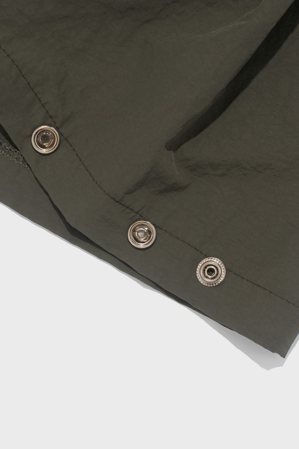 부드러운 촉감의 나일론 소재로 제작된 핀턱 디테일의 버뮤다 팬츠입니다. 루즈핏으로 편안하게 착용 가능하며, 허리 밴딩과 드로우스트링으로 사이즈 조절이 용이합니다. 봄, 여름 시즌 캐주얼 스타일을 연출하기 좋은 5부 기장의 카키색 바지입니다.
