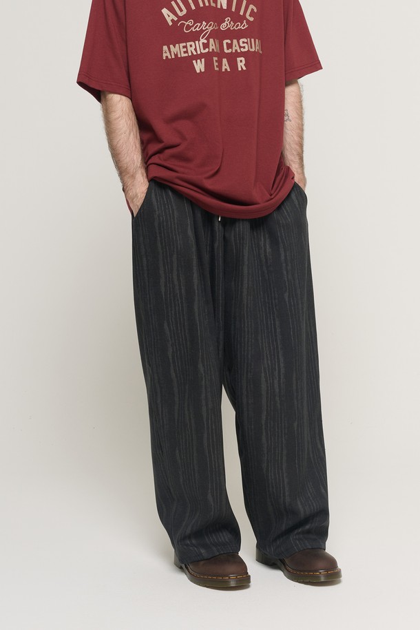 **STRIPE WASHING 데님 벌룬 팬츠 (블랙)**

빈티지 워싱 가공으로 은은한 멋을 더한 STRIPE WASHING 데님 벌룬 팬츠입니다. 면과 폴리에스테르 혼방 소재로 제작되어 편안한 착용감을 선사하며, 넉넉한 루즈핏과 와이드한 벌룬 실루엣으로 트렌디한 스타일을 연출합니다. 허리 밴딩과 스트링 디테일로 활동성을 높였으며, 봄, 가을 일상에서 캐주얼하고 미니멀한 무드를 즐기기에 좋습니다. 블랙과 네이비 두 가지 컬러로 출시되어 다양한 스타일을 소화할 수 있습니다. 산책이나 여행 시 편안하게 착용하기 좋은 아이템입니다.
