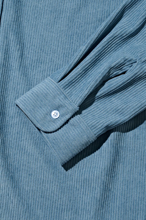 클래식 코듀로이 세미 셔츠 (블루)는 가을과 겨울에 어울리는, 부드러운 촉감의 두꺼운 코듀로이 소재로 제작된 남녀 공용 셔츠입니다. 차이나 칼라와 루즈핏 디자인으로 클래식하면서도 캐주얼한 스타일을 연출하며, 출근룩이나 비즈니스 캐주얼에 활용하기 좋습니다. 긴 소매와 포켓 디테일이 돋보이며, 무지 패턴의 블루 컬러가 미니멀한 무드를 더합니다. 
